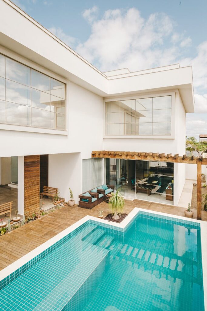 pexels-photo-5563472-5563472-1 Contemporary interior of lounge area with swimming pool located on terrace of luxury villa in sunny day